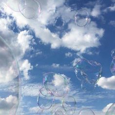 soap bubbles floating in the air on a sunny day with blue sky and white clouds