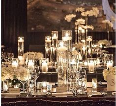 a table topped with lots of candles and vases filled with flowers next to each other