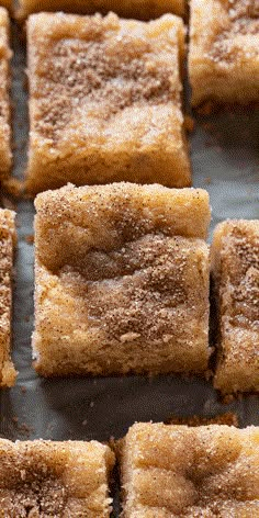 several square pieces of cake sitting on top of a pan covered in powdered sugar