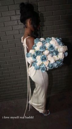 a woman holding a bouquet of flowers in front of a brick wall with the words i love my self