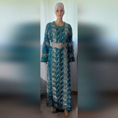 Step Into Timeless Elegance With Our Vintage Turquoise Moroccan Takshita, Size L. This Exquisite Garment, Boasting 20 Years Of History, Features Intricate Hand-Embroidered Details That Showcase The Finest Moroccan Craftsmanship. The Rich Turquoise Color And Delicate Silver Accents Highlight Its Regal Beauty, Perfect For Making A Statement At Weddings, Cultural Events, Or Special Gatherings. Despite Its Age, This Takshita Has Been Meticulously Cared For, Retaining Its Charm And Quality. Embrace T Cultural Events, Embroidered Details, Vintage Turquoise, Turquoise Color, Silver Accents, Fashion History, Blue And Silver, 20 Years, Hand Embroidered