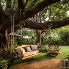 a wooden swing chair sitting on top of a lush green field next to a tree