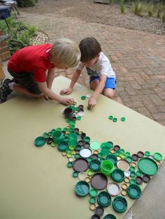 two young boys playing with bottle caps on a table