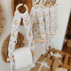 several white and gold macrame decorations hanging from hooks