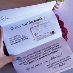 a person holding a piece of paper in front of a white envelope with the words o seu carto black on it