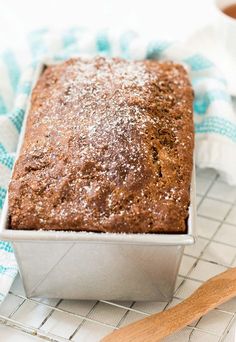 a loaf of bread sitting on top of a cooling rack next to a wooden spoon