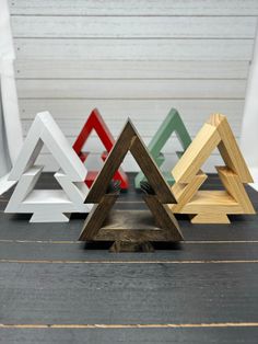 four different colored wooden triangles sitting on top of a table