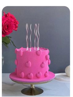 a pink cake sitting on top of a table