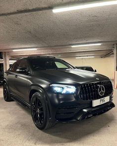 a black mercedes gle is parked in a parking garage