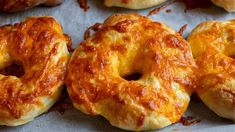 several cheese bagels are lined up on a baking sheet and ready to be eaten