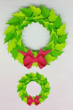 two christmas wreaths with red bows and green leaves on the top one is cut out to look like an origami