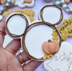 a hand holding a mickey mouse cookie with some decorations on the front and side of it