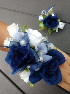 two wrist corsages with blue flowers and silver sequins on the wrist