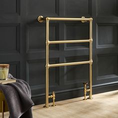 a bathroom with black walls and wooden flooring next to a gold radiator