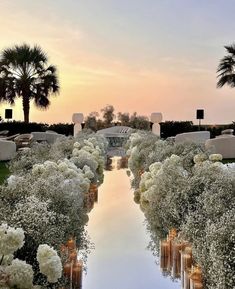 an outdoor ceremony with candles and flowers in the foreground, surrounded by palm trees