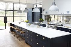 a large kitchen with blue cabinets and white counter tops