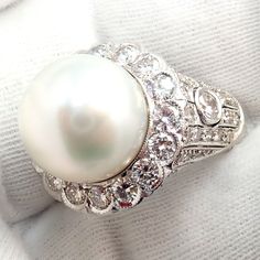 About This Piece: This Vintage Estate 18k White Gold Diamond 12.5mm Pearl Ring features a large, lustrous 12.5mm pearl set in a beautifully crafted 18k white gold cocktail ring. The pearl is accentuated by a halo of sparkling diamonds, adding a touch of elegance and sophistication to this timeless piece. Metal: 18k White Gold Stone: Diamonds: Approx 2ctw Size: 6, Resize Available Pearl: Bluish Silver High Luster 12.5mm Pearl Weight: 13.1g Hallmarks: 18k 89192 3227medd Pearl Cocktail Ring, Chanel Ring, Watch Cufflinks, Hermes Jewelry, Gold Cocktail Ring, Gold Cocktail, Pearl Set, Gold Stone, Cartier Ring