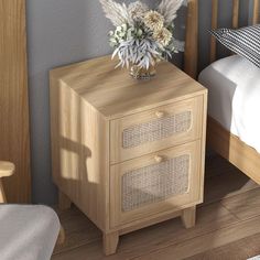 a wooden nightstand with two drawers next to a bed