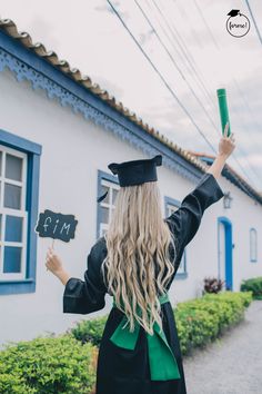 a woman in graduation gown holding up a chalkboard with the word faith written on it