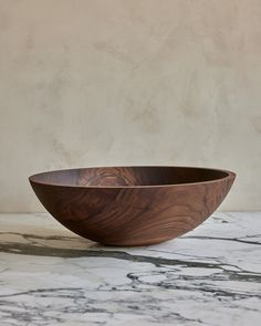 a wooden bowl sitting on top of a marble counter