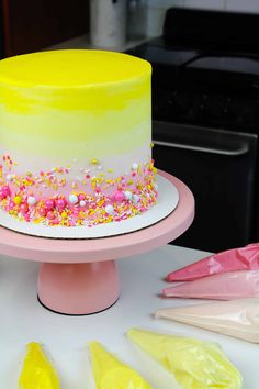 a yellow and white cake with sprinkles on it sitting on a table