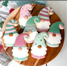 decorated cookies in the shape of gnomes on a wooden platter