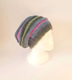 a white mannequin head wearing a multicolored knitted beanie hat