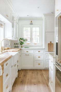 a kitchen with white cabinets and wood floors