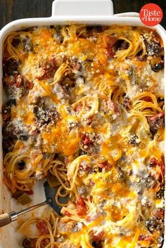 a casserole dish filled with pasta and meat, topped with cheese and sauce