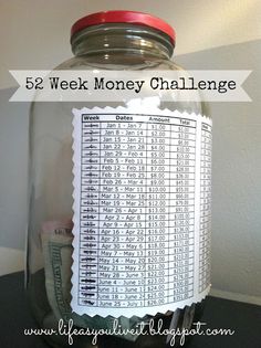 a jar filled with money sitting on top of a counter next to a sign that reads 52 week money challenge