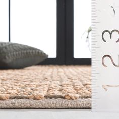 a close up of a ruler on the floor next to a bed with a pillow