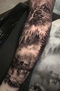 a man's arm with trees and mountains on it