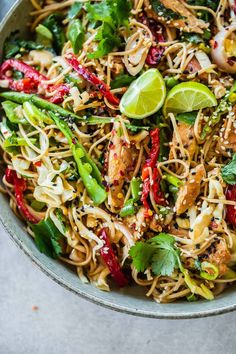 a bowl filled with noodles, chicken and vegetables