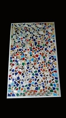 a mosaic tile with many different colors and shapes on it's surface, in the dark