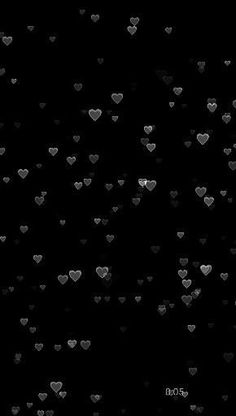 many hearts floating in the air on a black background