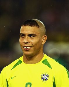 a soccer player is smiling and wearing a yellow shirt with green trim on his face