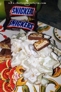 a plate topped with whipped cream next to a bar of snickker's