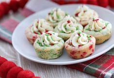 some cupcakes on a white plate with red and green decorations