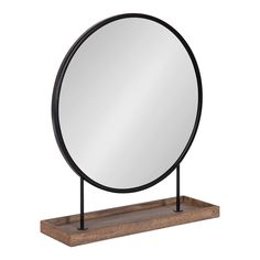 a round mirror sitting on top of a wooden stand