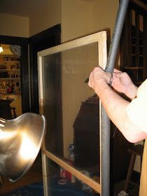 a man holding onto a metal pole in front of a window