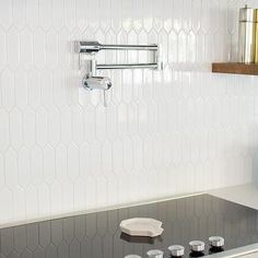 a stove top oven sitting inside of a kitchen next to a wall mounted faucet