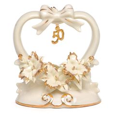 an ornament shaped like a swan with flowers on it's back and gold accents