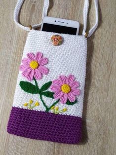 a crocheted cell phone case with flowers on it