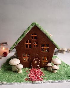 a gingerbread house with mushrooms and grass around it