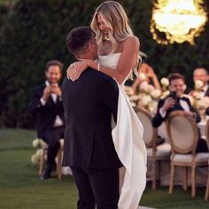 the bride and groom are hugging each other at their wedding reception in front of an audience