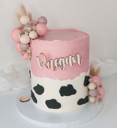 a pink and white cake with black polka dots