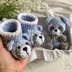 two small crocheted teddy bears sitting next to each other in front of flowers