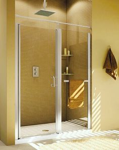 a bathroom with a walk in shower sitting next to a sink and a towel rack