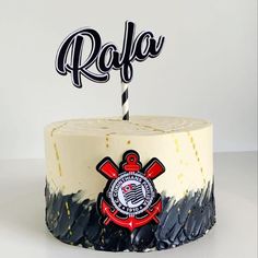 a white cake with black frosting and a red firefighter's emblem on top