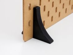 a close up of a piece of cardboard with holes in the middle and a black handle